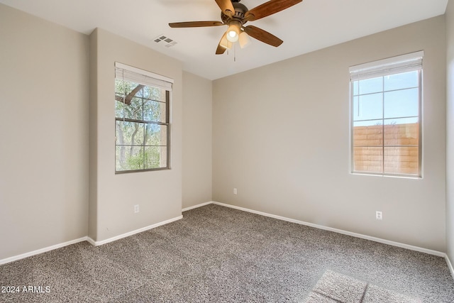 carpeted spare room featuring ceiling fan