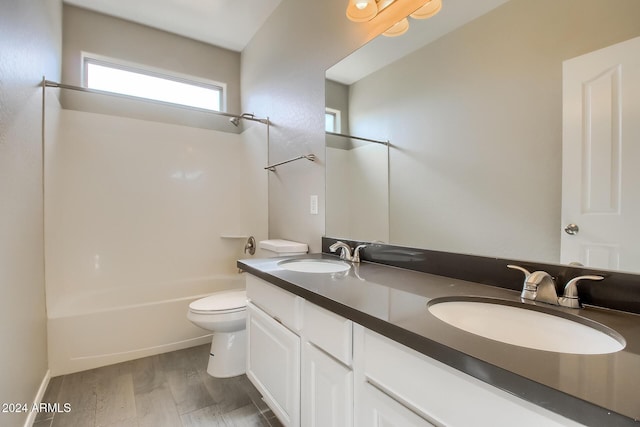 full bathroom with hardwood / wood-style floors, vanity, shower / bath combination, and toilet