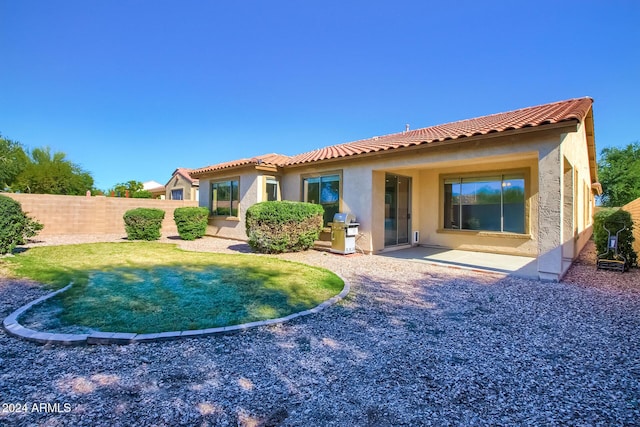 back of house with a lawn and a patio