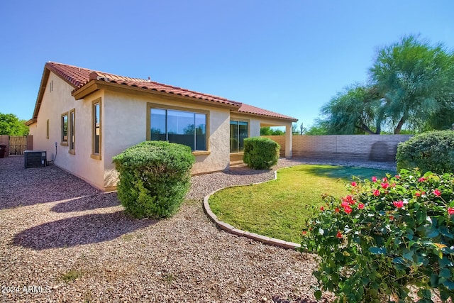 back of property with a lawn and central air condition unit