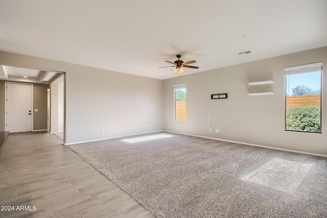 spare room with ceiling fan, plenty of natural light, and light hardwood / wood-style floors