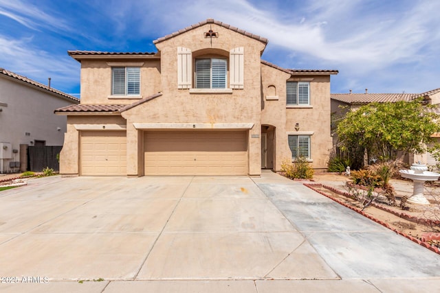 mediterranean / spanish house with a garage, concrete driveway, and stucco siding