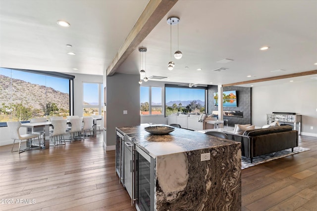 kitchen with a mountain view, decorative light fixtures, dark hardwood / wood-style floors, and beamed ceiling