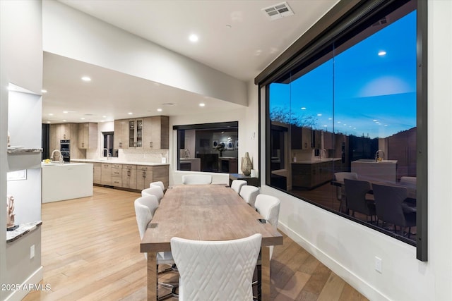 dining area with sink and light hardwood / wood-style flooring