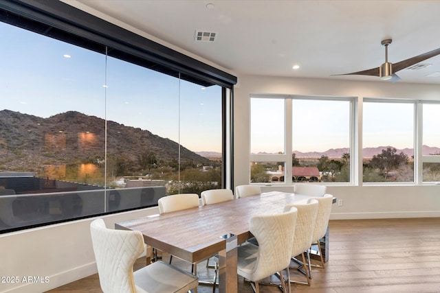 sunroom featuring ceiling fan and a mountain view