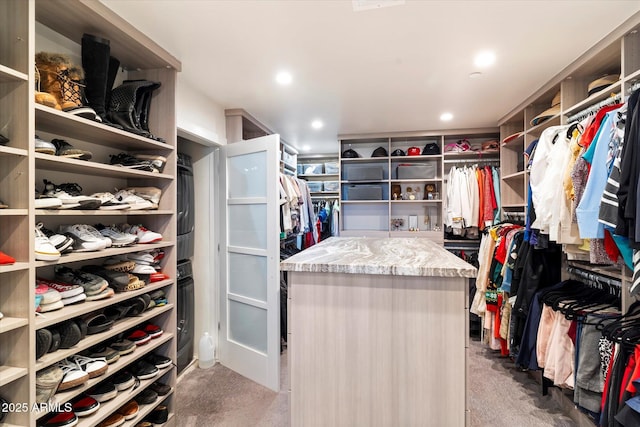 walk in closet featuring light colored carpet