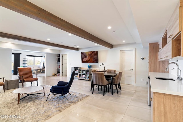 dining room with beam ceiling and sink