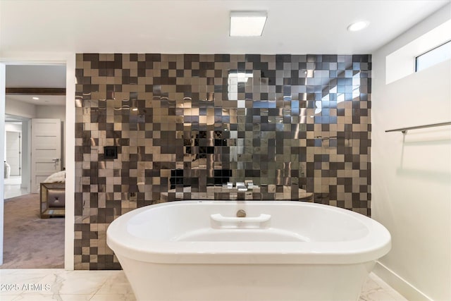 bathroom featuring a tub and tile walls