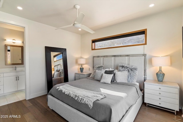 bedroom with connected bathroom, dark hardwood / wood-style floors, sink, and ceiling fan