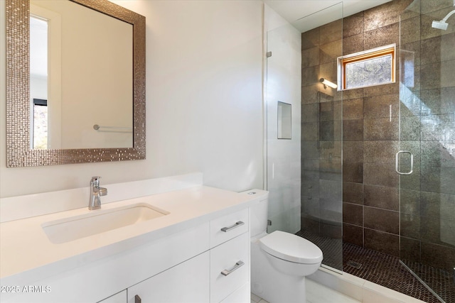 bathroom featuring walk in shower, vanity, and toilet