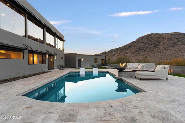 view of swimming pool featuring a mountain view, an outdoor living space with a fire pit, and a patio