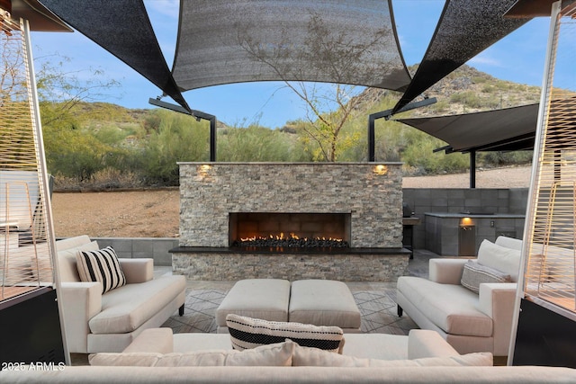 view of patio with an outdoor living space with a fireplace