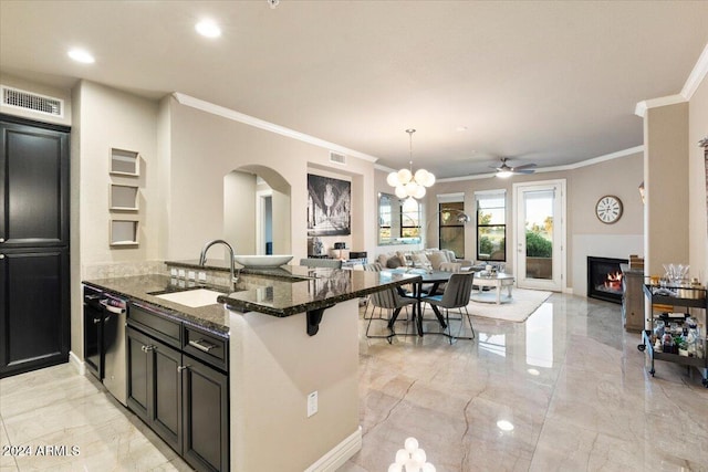 kitchen featuring sink, dishwasher, dark stone counters, decorative light fixtures, and ornamental molding