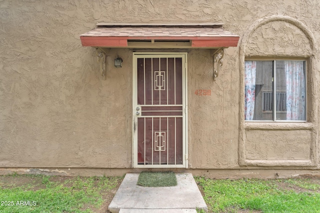 entrance to property featuring stucco siding