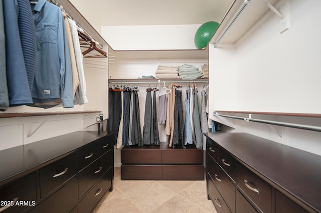 walk in closet with light tile patterned floors
