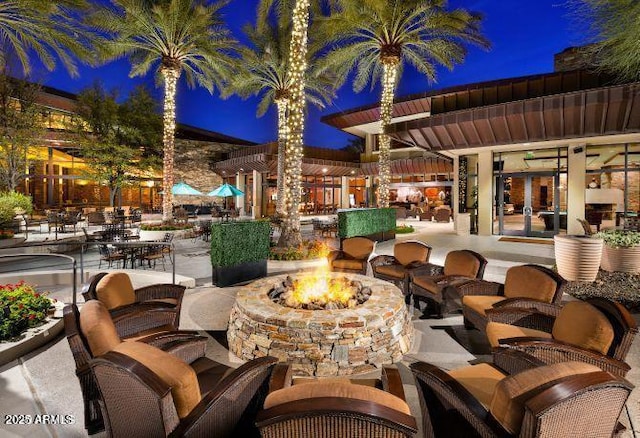 patio at twilight featuring a fire pit