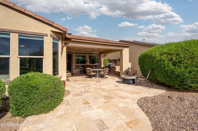 view of patio / terrace with area for grilling and a fire pit