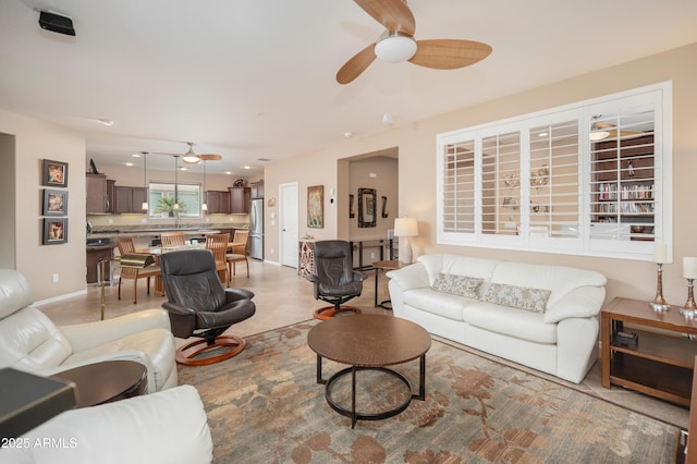 living room featuring baseboards and a ceiling fan
