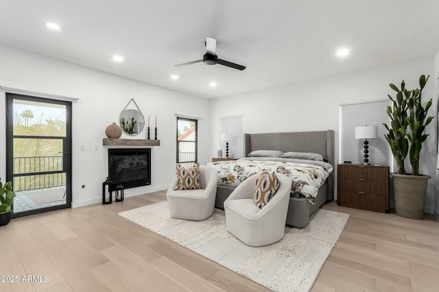 bedroom featuring access to exterior, multiple windows, and light wood-style floors