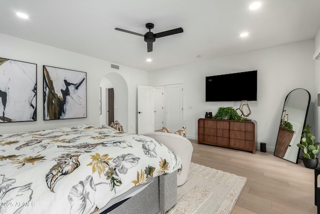 bedroom with visible vents, light wood finished floors, recessed lighting, arched walkways, and ceiling fan