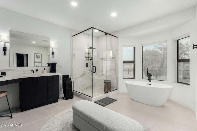 full bath with tile patterned floors, recessed lighting, a marble finish shower, a soaking tub, and vanity