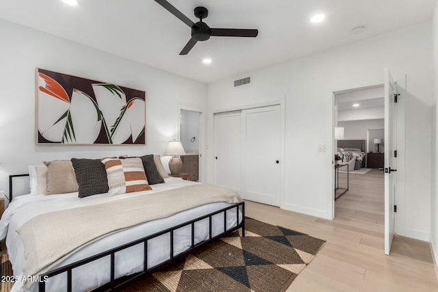 bedroom featuring light wood finished floors, visible vents, baseboards, recessed lighting, and a closet