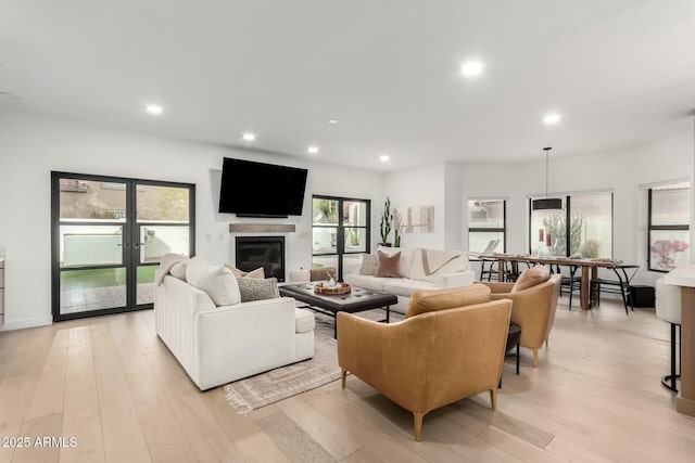 living area featuring a wealth of natural light, recessed lighting, french doors, and light wood-type flooring