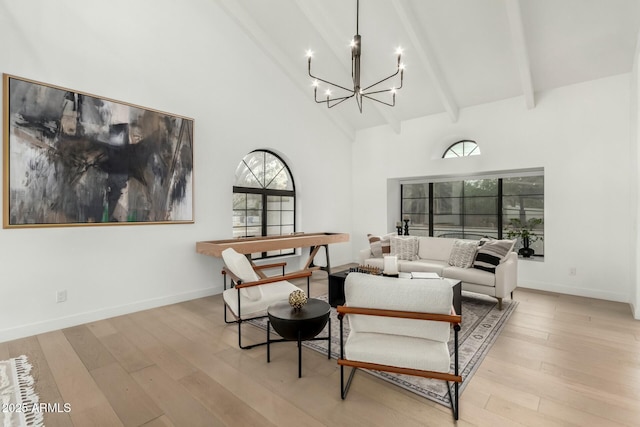 living area featuring beam ceiling, high vaulted ceiling, wood finished floors, baseboards, and a chandelier