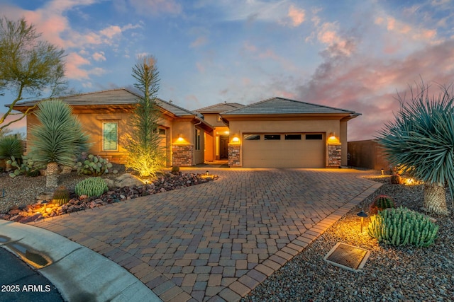 6251 E Bramble Berry Ln, Cave Creek, AZ 85331 - view of front of house with an attached garage, decorative driveway, stone siding, and stucco siding