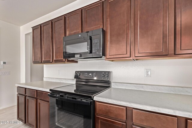 1268 E Jahns Dr, Casa Grande, AZ 85122 - kitchen with light wood-style floors, light countertops, baseboards, and black appliances