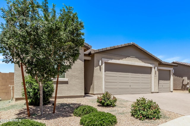 1268 E Jahns Dr, Casa Grande, AZ 85122 - view of front of house featuring fence, an attached garage, driveway, and stucco siding