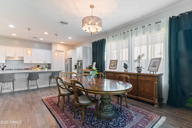 dining space with recessed lighting, visible vents, a notable chandelier, and wood finish floors