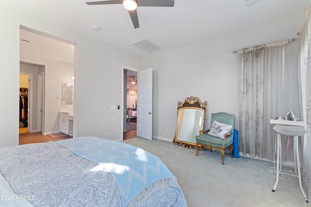 bedroom featuring connected bathroom, a spacious closet, light colored carpet, and ceiling fan