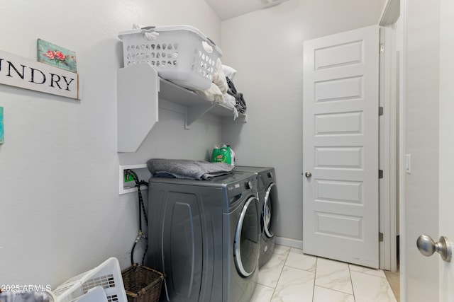 washroom featuring marble finish floor, laundry area, washing machine and dryer, and baseboards