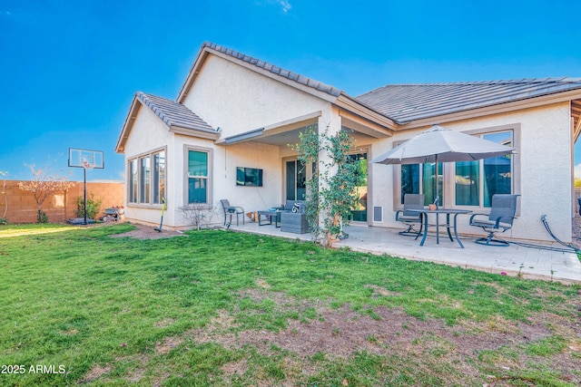 back of house with a tile roof, stucco siding, a lawn, a patio area, and fence