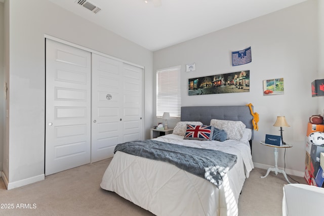 carpeted bedroom with a closet, visible vents, and baseboards