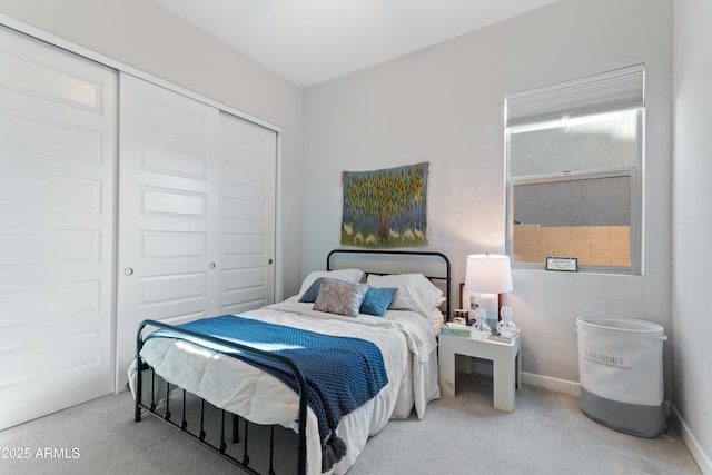 carpeted bedroom with a closet and baseboards