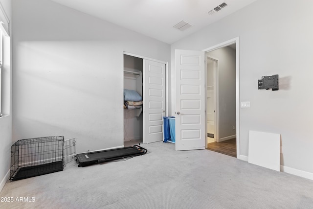 interior space with carpet floors, a closet, visible vents, and baseboards