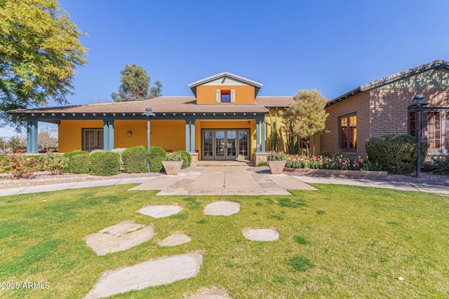 view of front of home with a front lawn and french doors