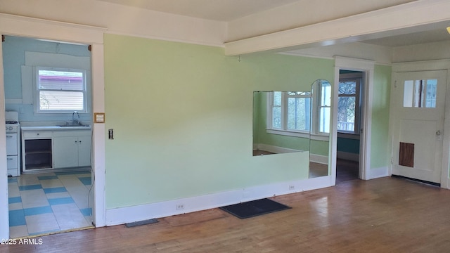 unfurnished room featuring sink and hardwood / wood-style floors