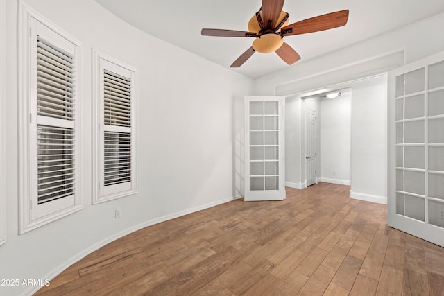 spare room with hardwood / wood-style floors, ceiling fan, and french doors