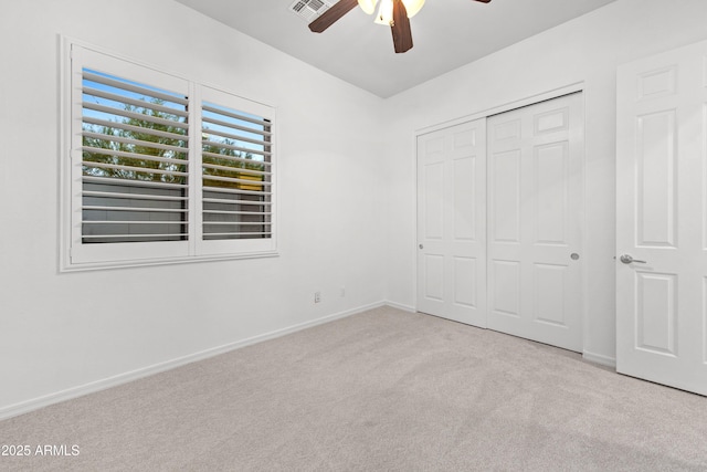 unfurnished bedroom featuring light colored carpet, ceiling fan, and a closet