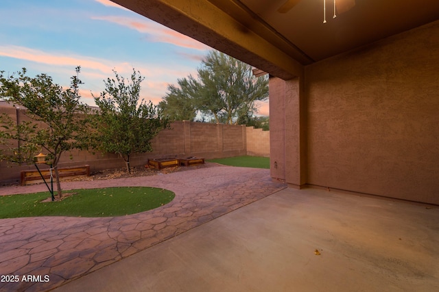 patio terrace at dusk featuring ceiling fan