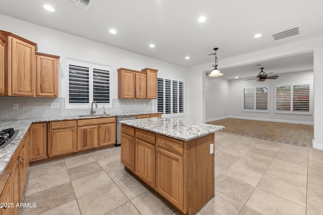 kitchen with sink, backsplash, a kitchen island, decorative light fixtures, and stainless steel dishwasher