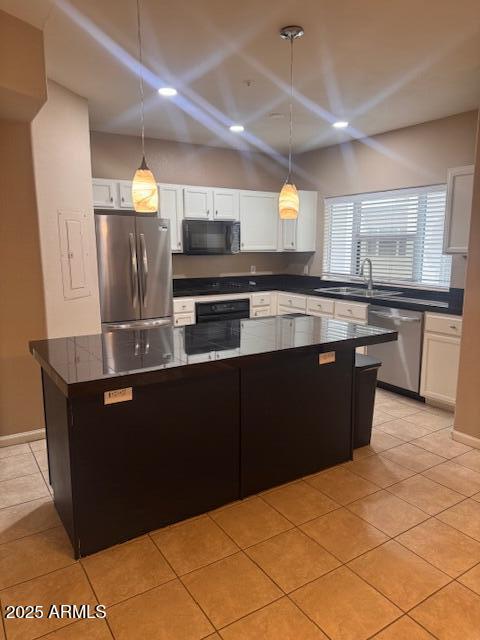 1081 W 1st St Unit 10, Tempe, AZ 85281 - kitchen featuring appliances with stainless steel finishes, dark countertops, white cabinets, light tile patterned floors, and a center island