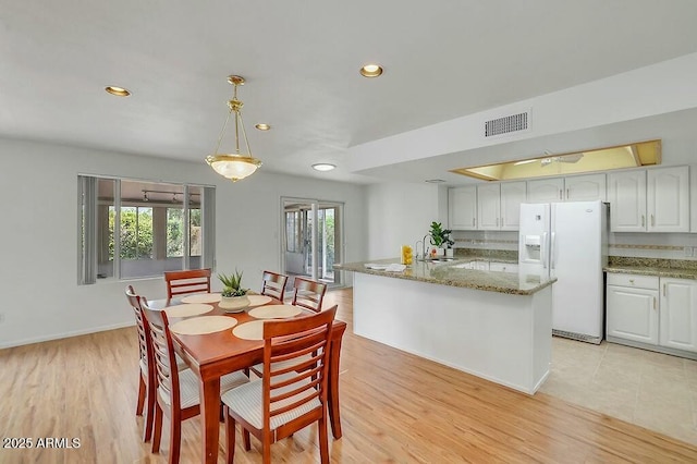 dining room featuring baseboards, visible vents, recessed lighting, and light wood-type flooring