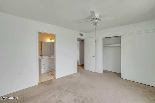 unfurnished bedroom with connected bathroom, a closet, a ceiling fan, light carpet, and visible vents