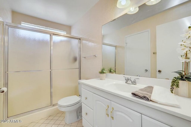 bathroom with tile patterned flooring, vanity, toilet, and an enclosed shower