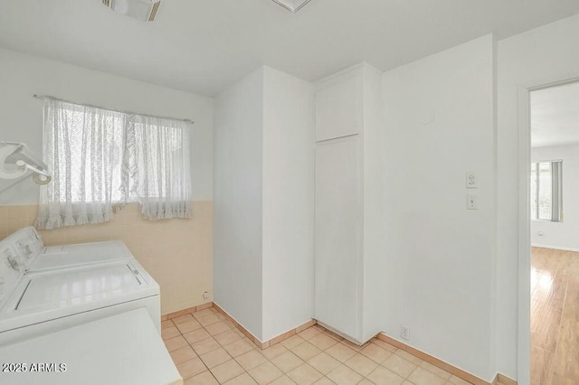 laundry room featuring washing machine and dryer, visible vents, laundry area, and light tile patterned floors