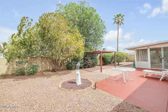 view of yard featuring a fenced backyard, a sunroom, and a patio area